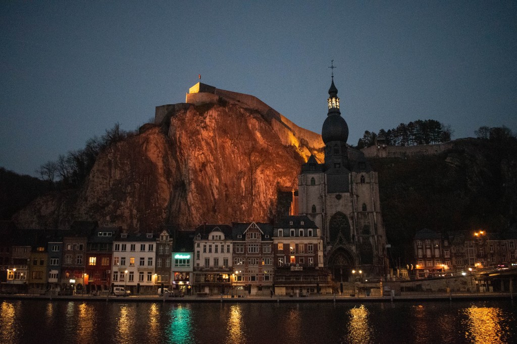 dinant église et citadelle au bord de la meuse le soir