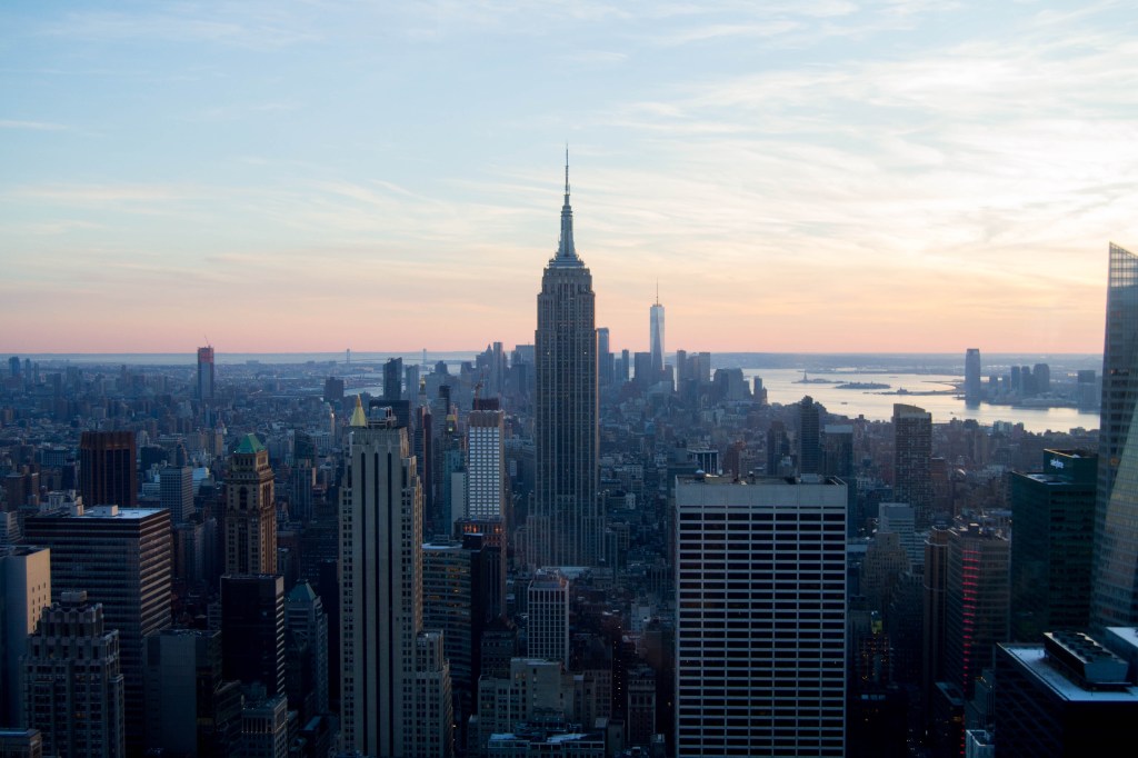 Vue depuis la tour rockfeller sur new york et l'empire state building au coucher du soleil