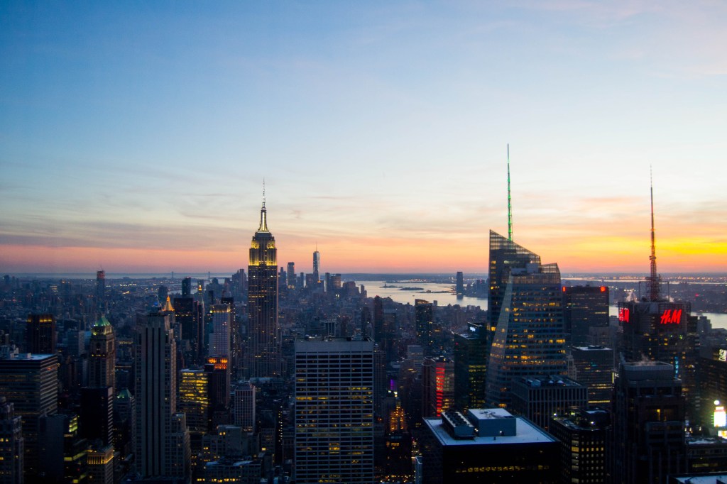 Vue depuis la tour rockfeller sur new york et l'empire state building au coucher du soleil
